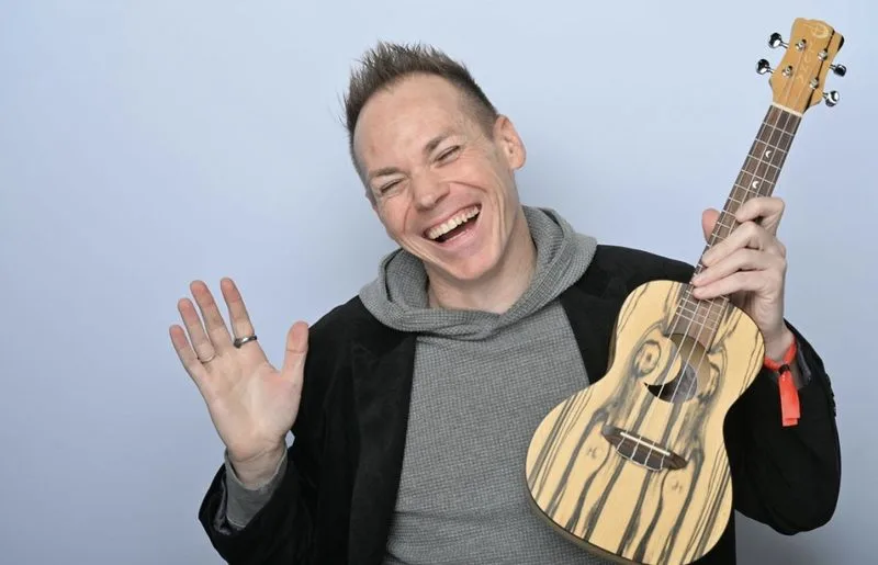 Ryan Today smiling and holding a ukulele