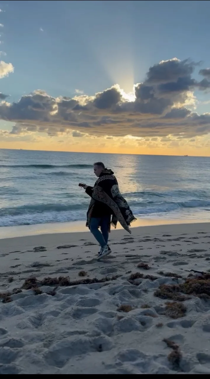 Ryan Today walking along the beach at sunset while playing ukulele
