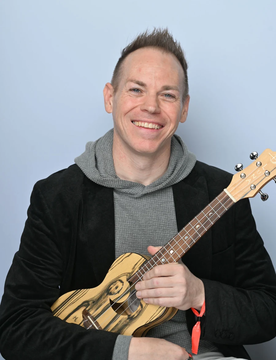 Ryan Today holding a ukulele and smiling